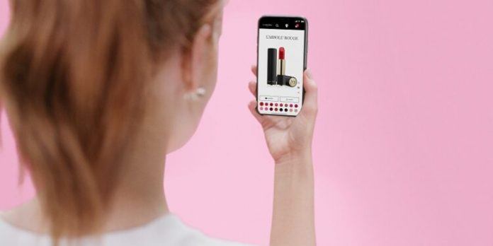 Mujer con celular en la mano mostrando publicidad de labiales
