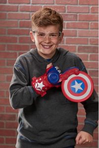 Niño con lentes y mano de juguete de capitán américa