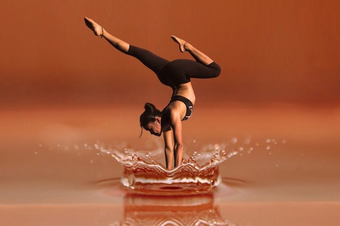 Mujer con ropa deportiva negra, practicando ejercicios en agua