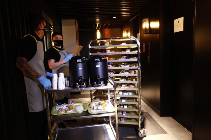 Interior de hotel, personas trasladando carritos de comida