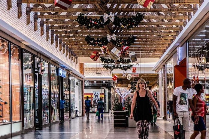 Centro comercial con adornos de navidad, personas caminado y observando tiendas