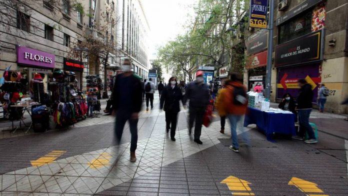 Calles con locales comerciales y persona caminado