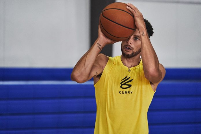 Hombre con balón de basquet y camiseta amarilla curry