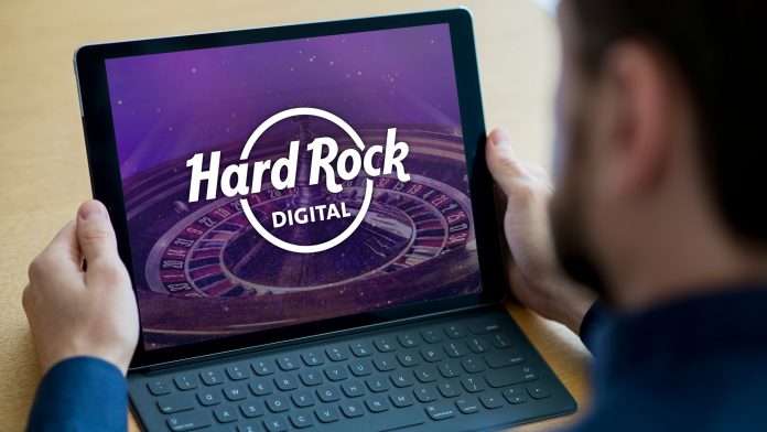 Hombre con laptop y publicidad hard rock digital