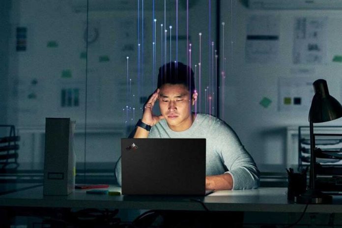 Hombre sentado frente a una computadora con panel digital