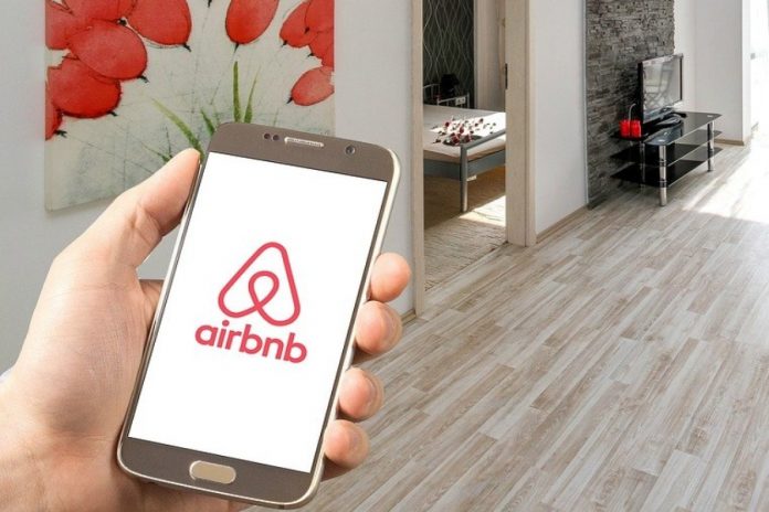 Persona usando la aplicación de Airbnb en su teléfono