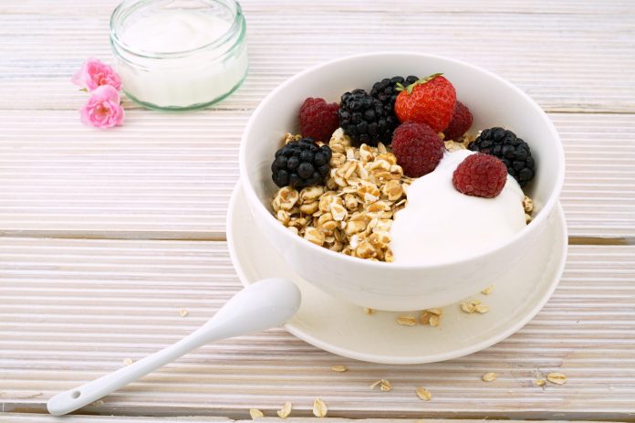 Mesa, taza de cereal con frutos y leche