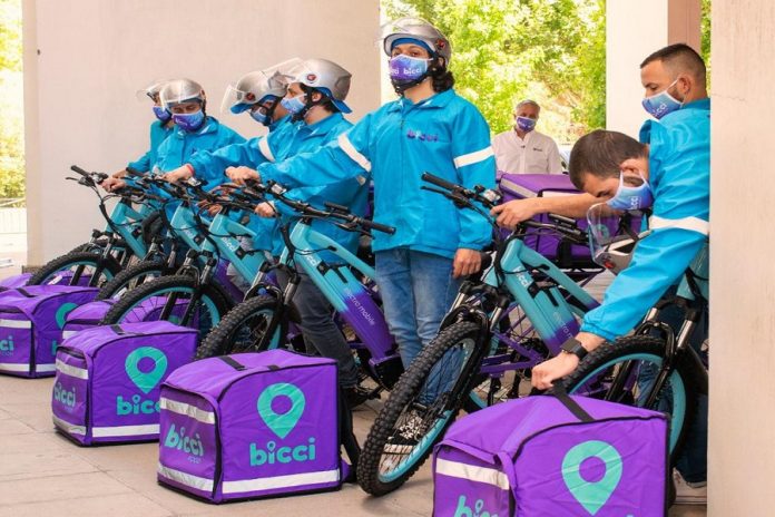 Personas con bicicletas y cajas de delivery AppBici
