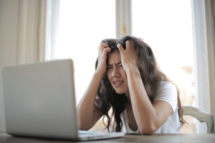mujer con estres laboral frente a un computador