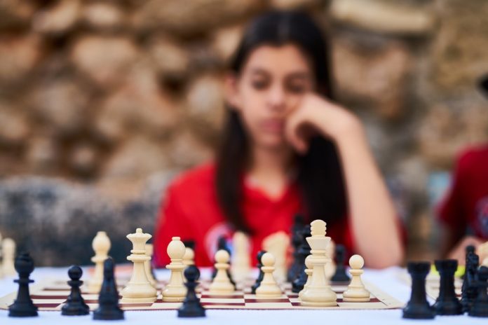 Mujer observando tablero de ajedrez