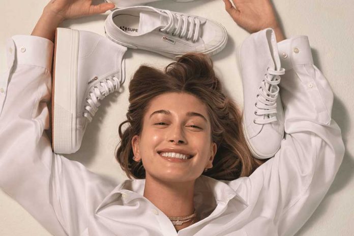 Mujer vestida de blanco con zapatos deportivos blancos