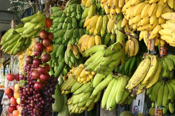 Estantería con frutas, bananos, manzanas y uvas