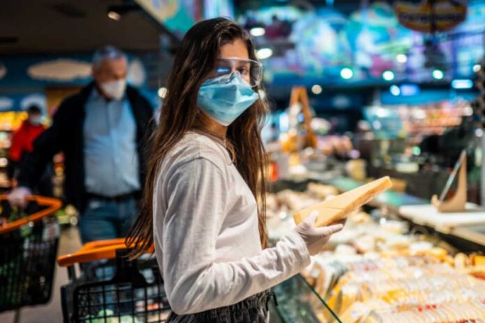 Mujer con tapabocas de compras en un supermercado