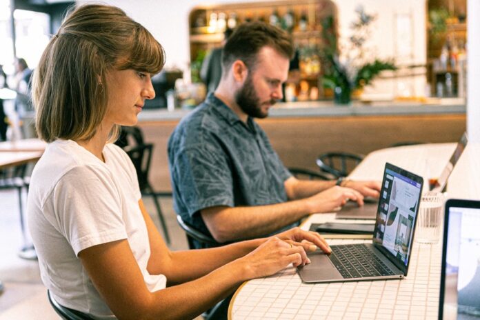 Mesa con laptop personas trabajando