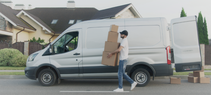 Camioneta blanca, hombre con cajas haciendo delivery