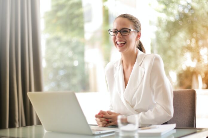 Mujer sonriendo trabajando con laptop