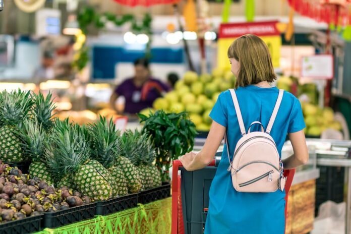 Mujer comprando frutas en un supermercado cebollas. Enero
