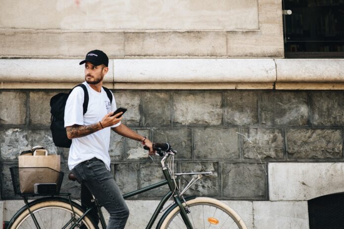 Hombre con bicicleta y celular en las manos