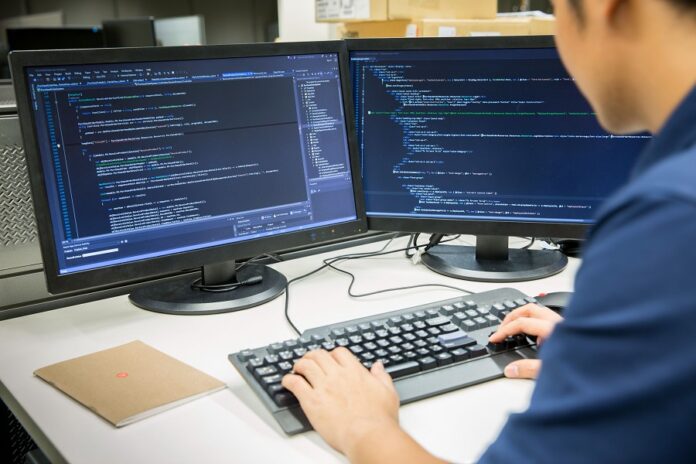 Hombre trabajando con computadora y programación