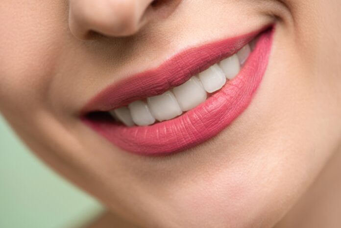 Mujer sonriendo con los labios pintado de rojo
