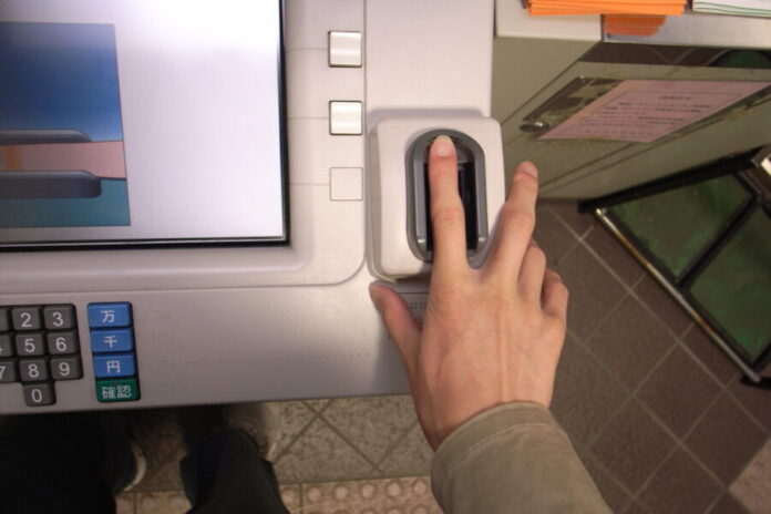 Persona colocando su huella dactilar en un cajero automático