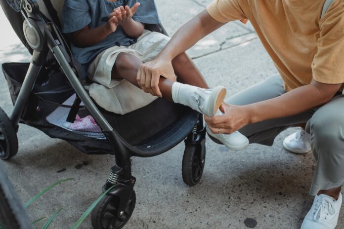 Padre poniéndole el calzado infantil blanco a su hijo