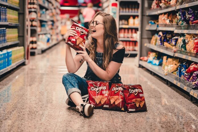 Mujer con paquetes de doritos en supermercado