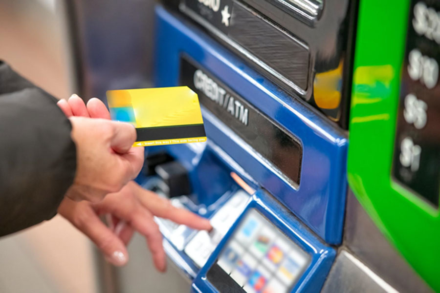 Hombre usando tarjeta en un ATM