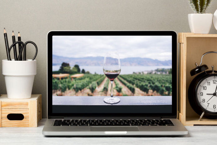 Imagen de un Viñedo y copa de vino en una laptop