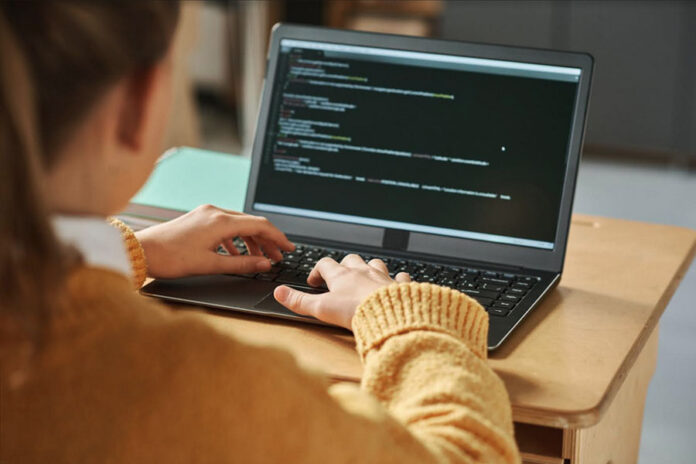 Mujer programadora trabajando en su laptop, presencia femenina